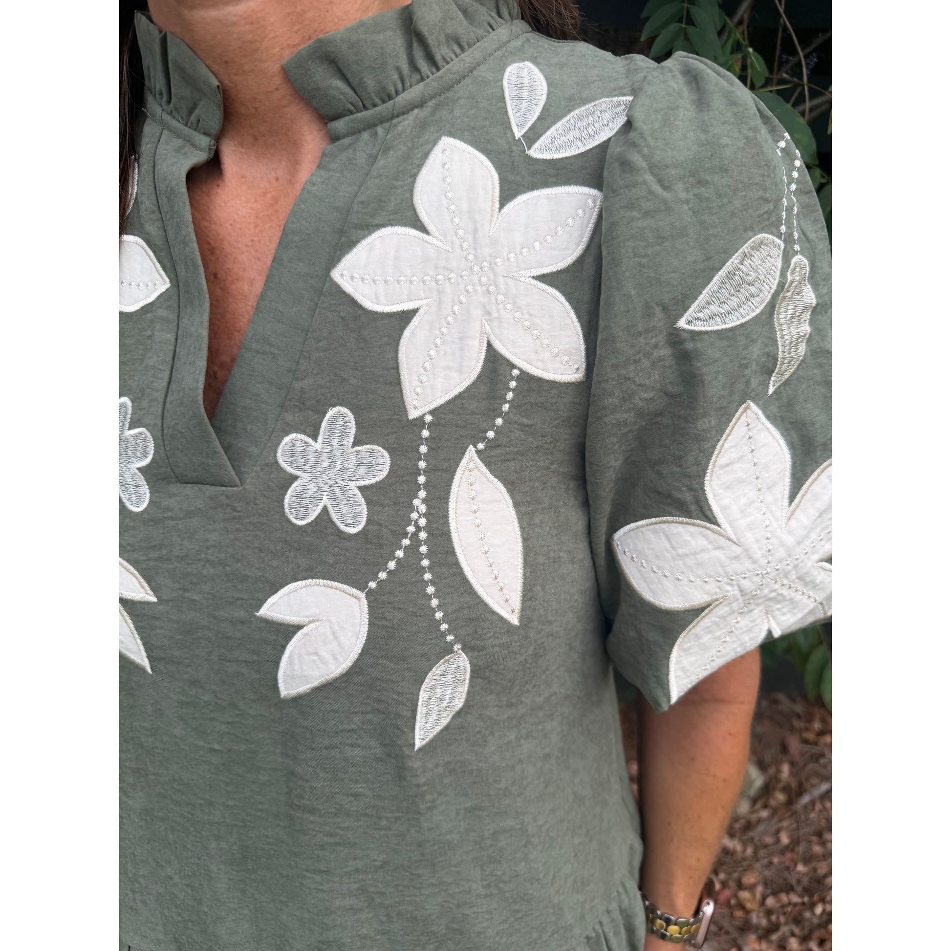 Annie Ks Boutique olive mini dress featuring white floral applique embroidery, split neckline, and puff sleeves.