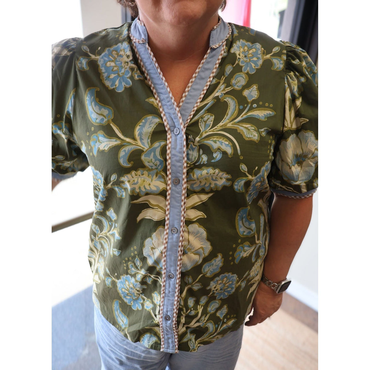 Annie Ks Boutique olive floral print cotton top with short puff sleeves, button-front, and contrast trim details.