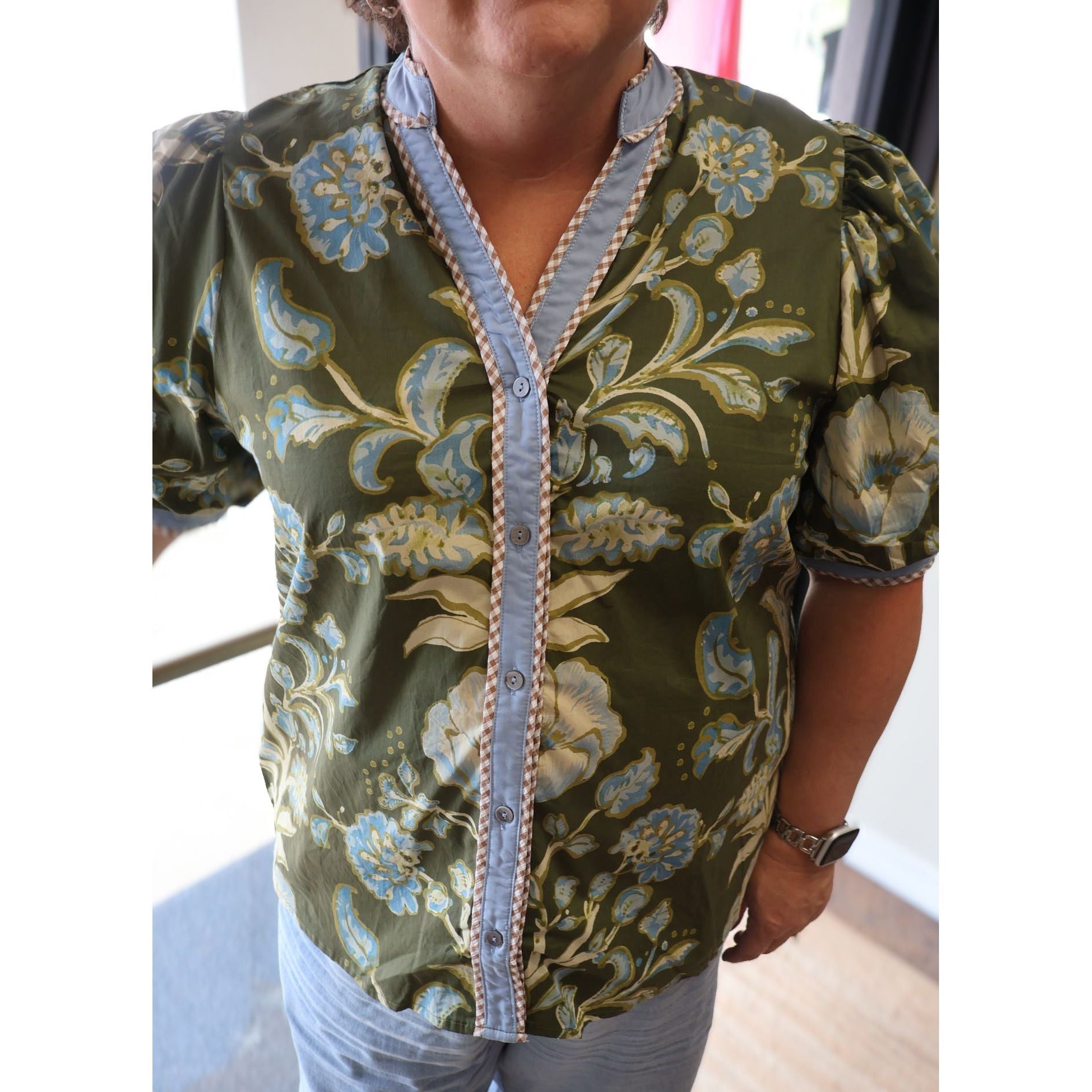 Annie Ks Boutique olive floral print cotton top with short puff sleeves, button-front, and contrast trim details.