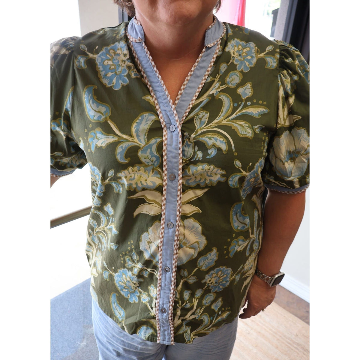 Annie Ks Boutique olive floral cotton top with short puff sleeves, button-front closure, and contrast trim details.