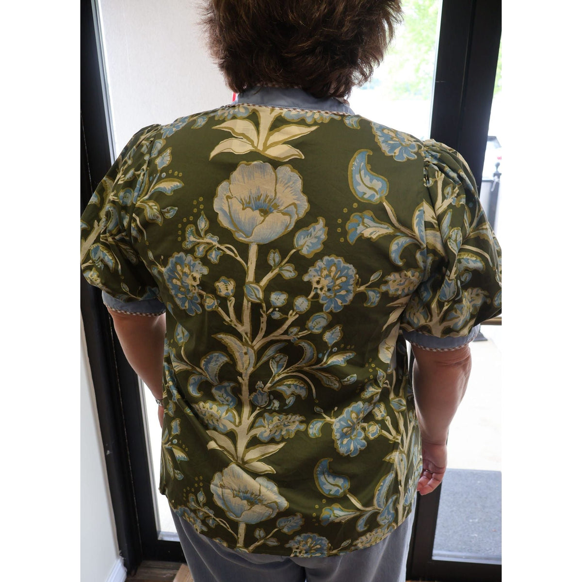 Annie Ks Boutique olive floral puff sleeve cotton top with blue contrast trim viewed from the back