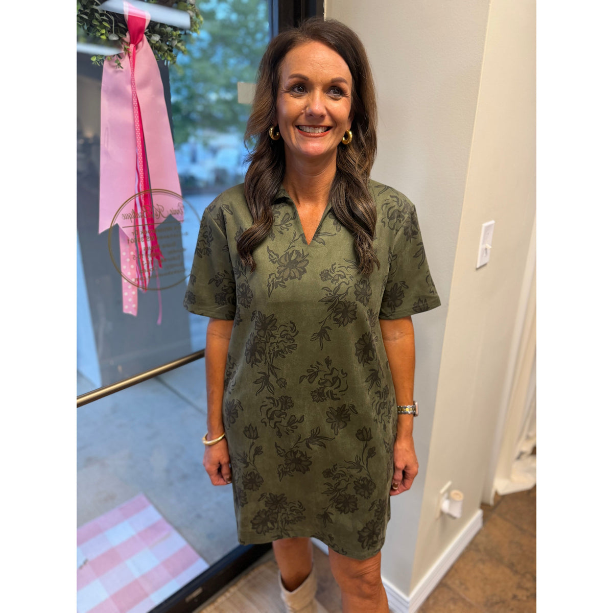 Annie Ks Boutique olive faux suede mini dress with a floral print, structured collar, and short sleeves on a model.