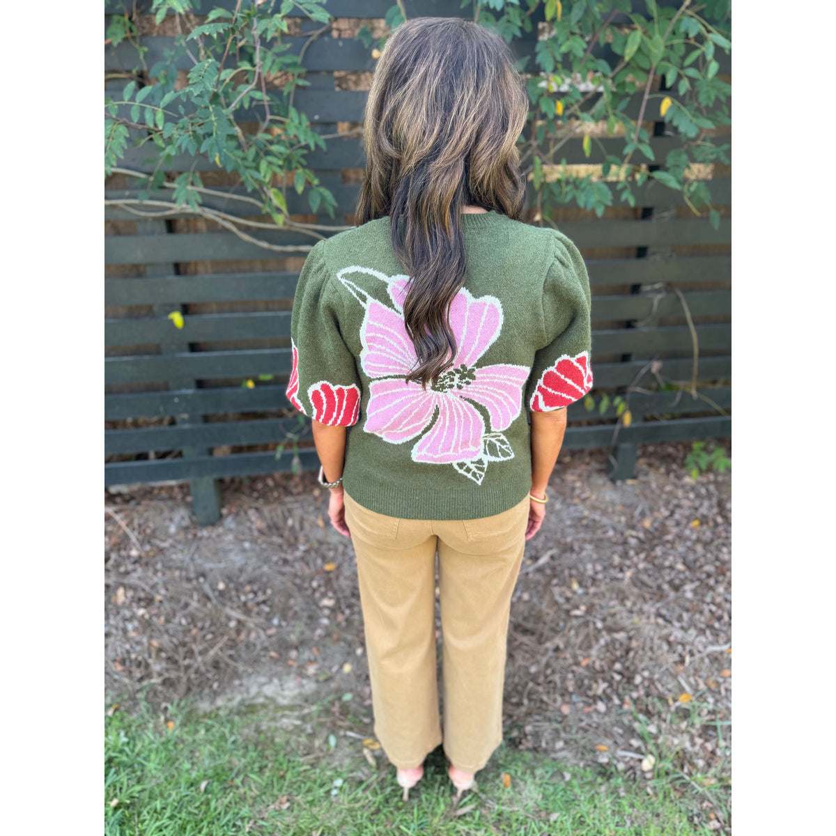 Annie Ks Boutique olive green knit sweater with pink floral print and puff sleeves worn with tan trousers