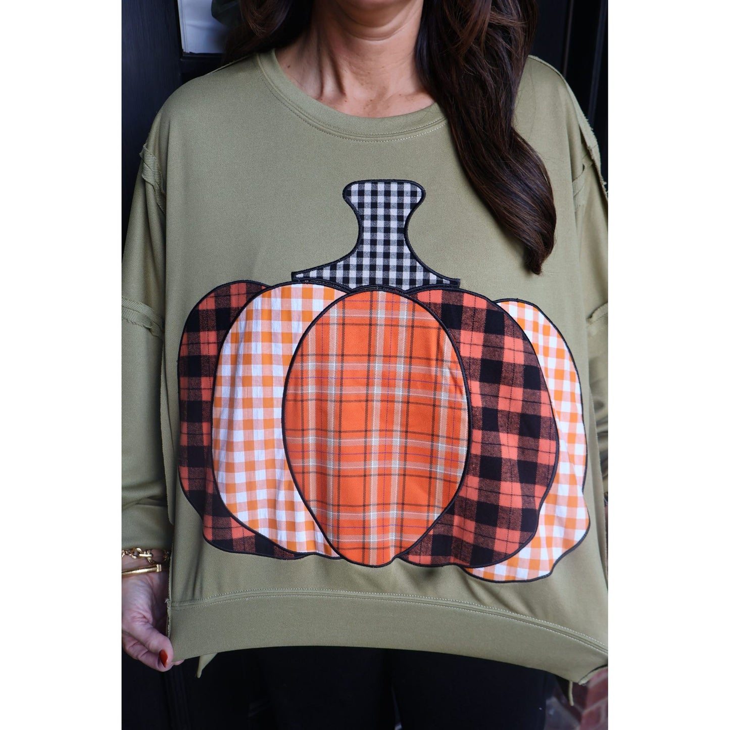 Annie Ks Boutique olive green French terry sweatshirt featuring a patchwork plaid pumpkin graphic with raw-edge detail