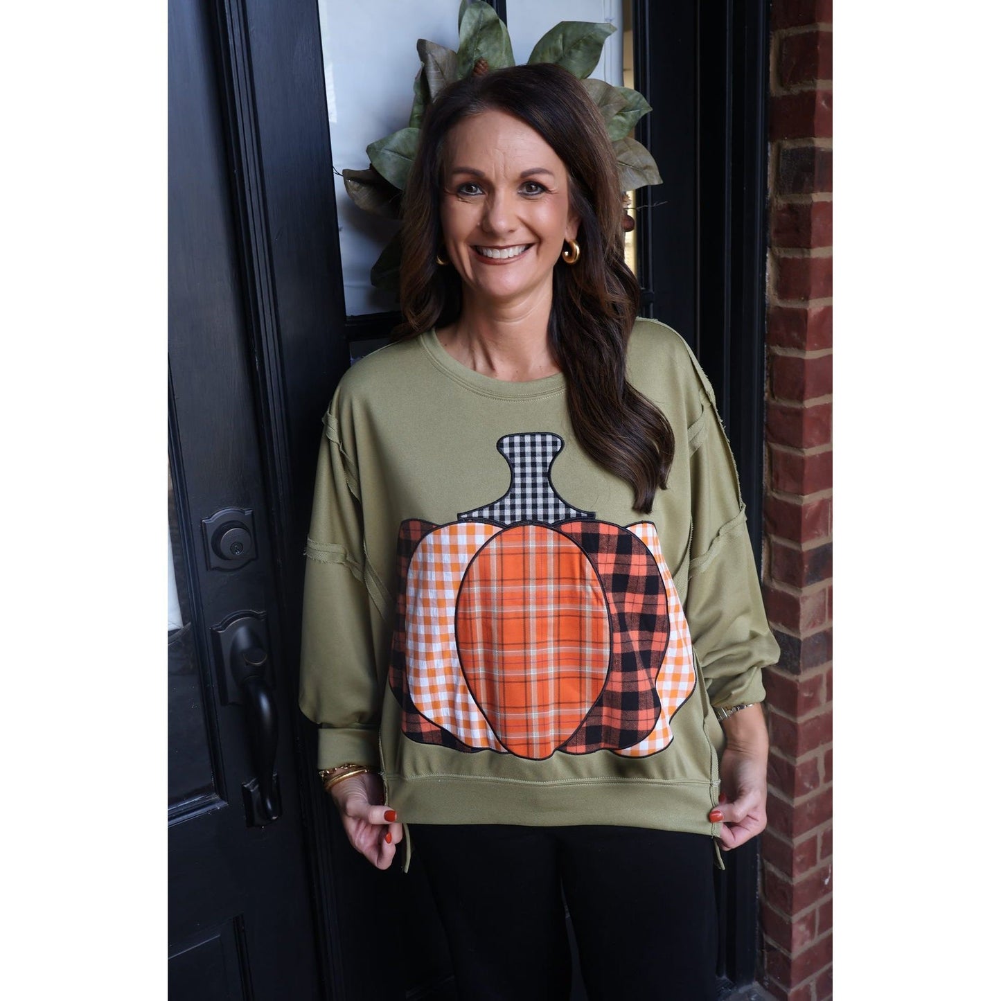 Annie Ks Boutique olive green French terry sweatshirt with a plaid patchwork pumpkin graphic and raw-edge detailing.