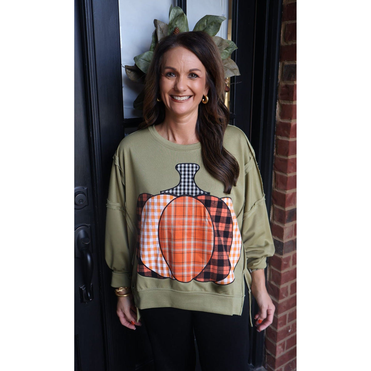Annie Ks Boutique olive green French terry sweatshirt with a plaid patchwork pumpkin graphic and raw-edge detailing.