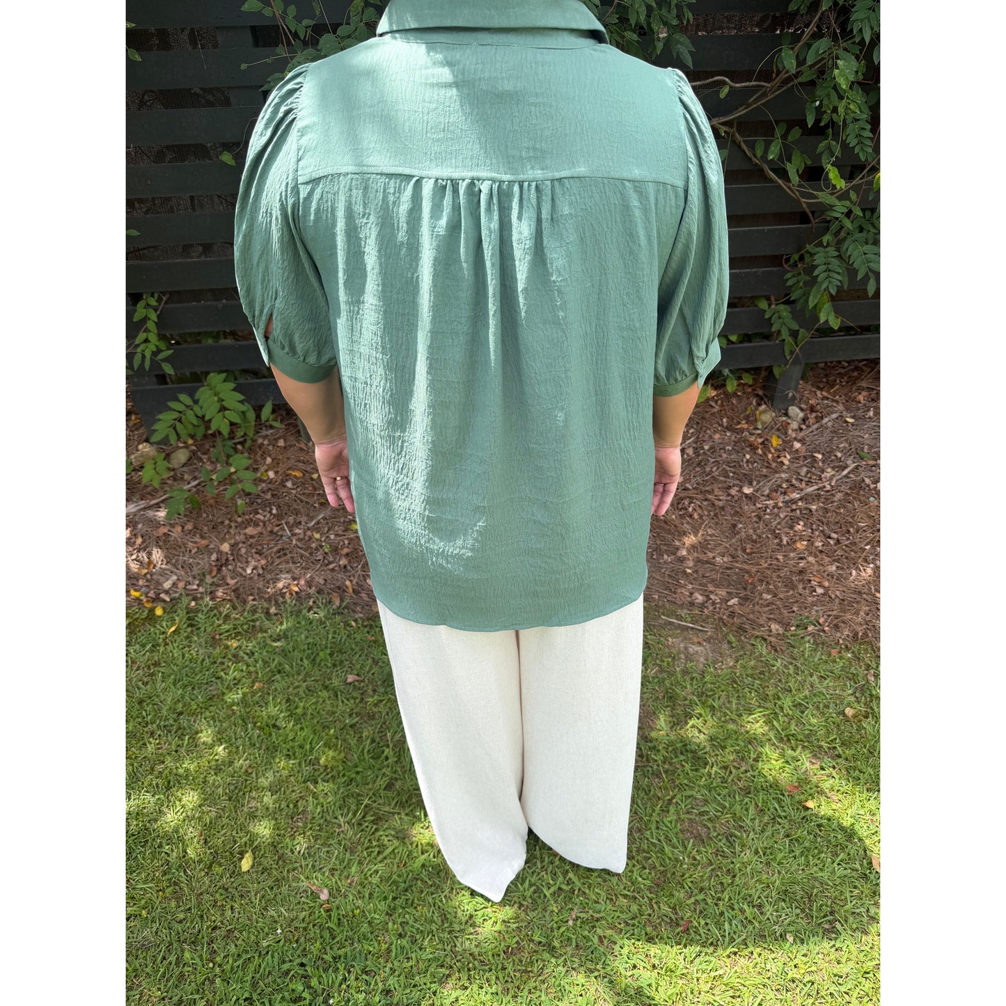 Annie Ks Boutique olive green collared blouse with puff sleeves and gathered back detail worn with white trousers