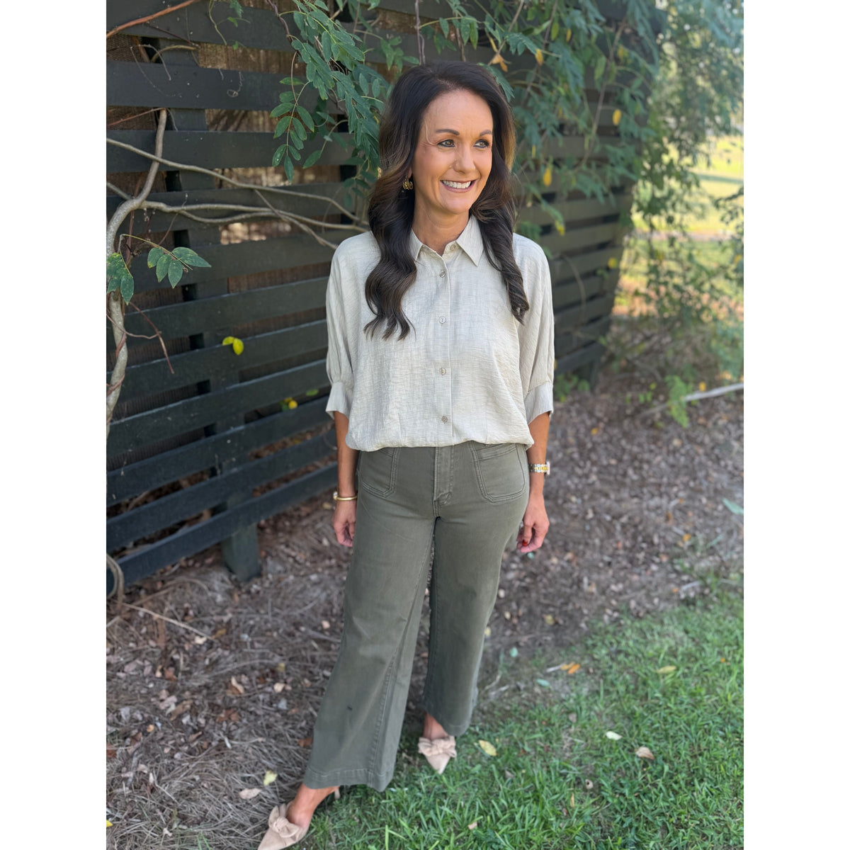 Annie Ks Boutique Nandor high-rise wide leg crop pants in olive green cotton-stretch blend worn by a smiling woman