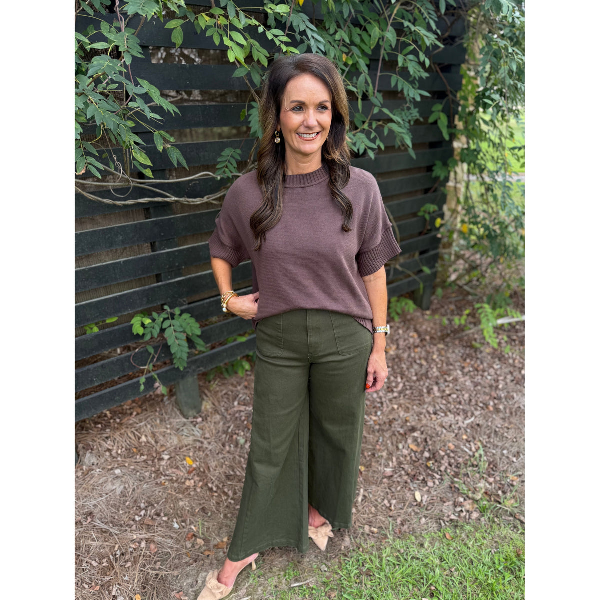 Annie Ks Boutique olive wide-leg trousers paired with a brown knit top, worn by a woman standing outdoors.