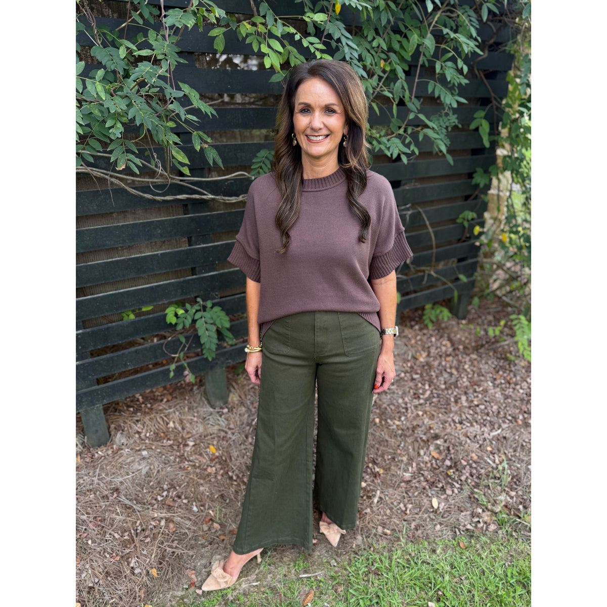 Annie Ks Boutique olive wide-leg trousers paired with a brown knit top, worn by a woman outdoors.