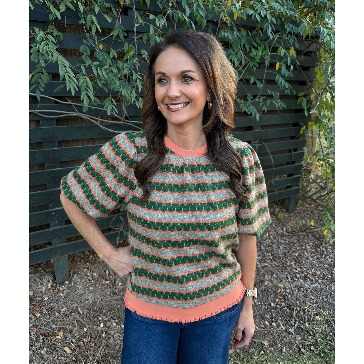 Annie Ks Boutique orange and green geometric stripe knit top with bubble sleeves and ribbed trim worn by a woman