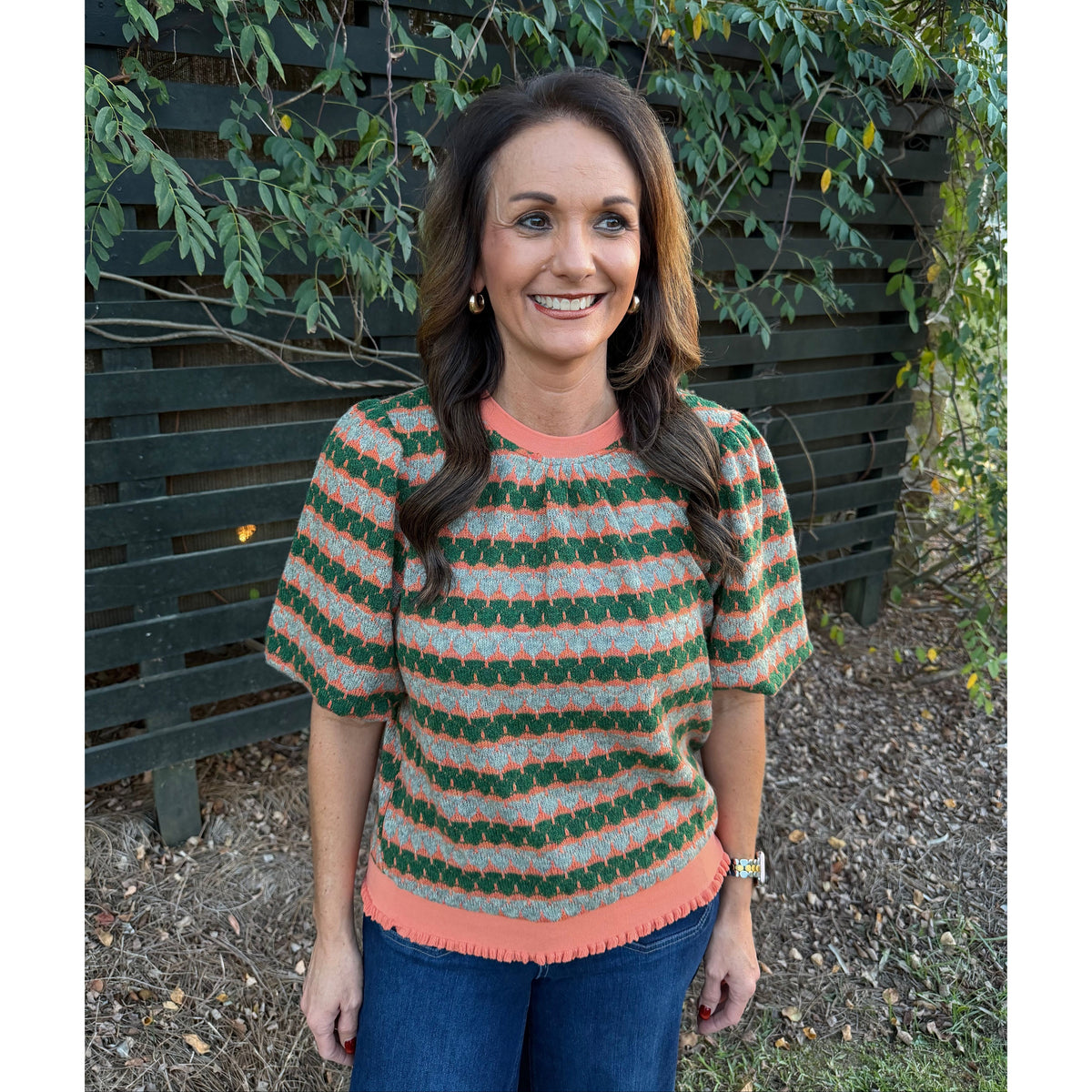 Annie Ks Boutique orange and green geometric stripe knit top with bubble sleeves and ribbed trim worn by a woman