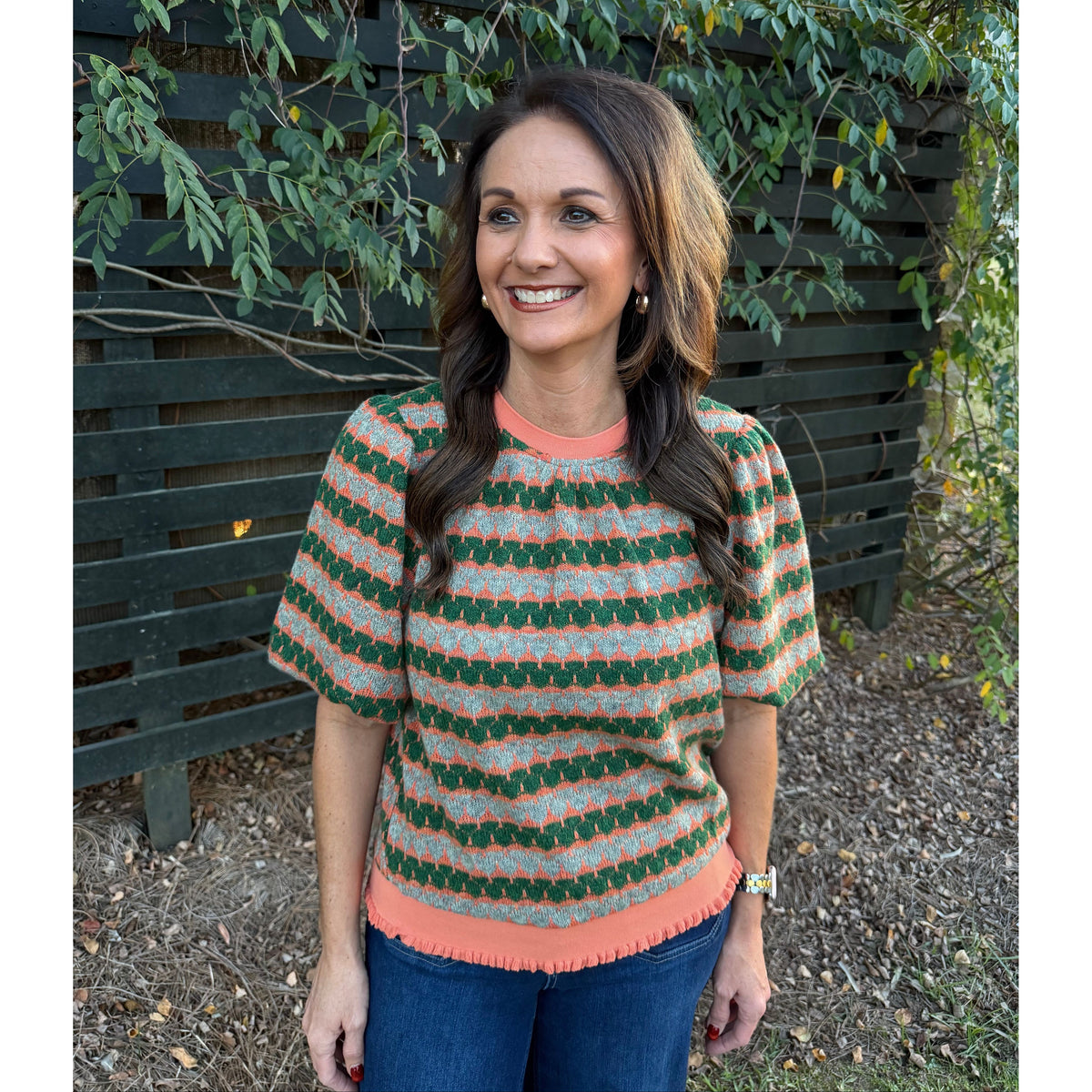 Annie Ks Boutique orange and green geometric stripe knit top with bubble sleeves and ribbed trim worn by a woman