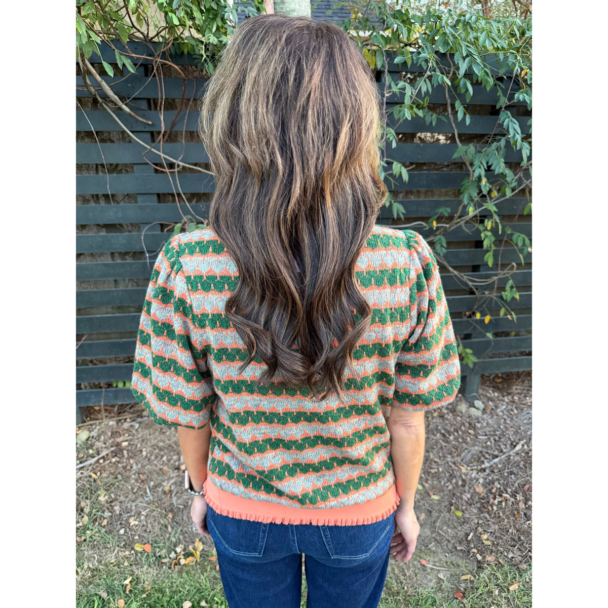 Back view of Annie Ks Boutique orange and green geometric stripe knit top with bubble sleeves and ribbed hem