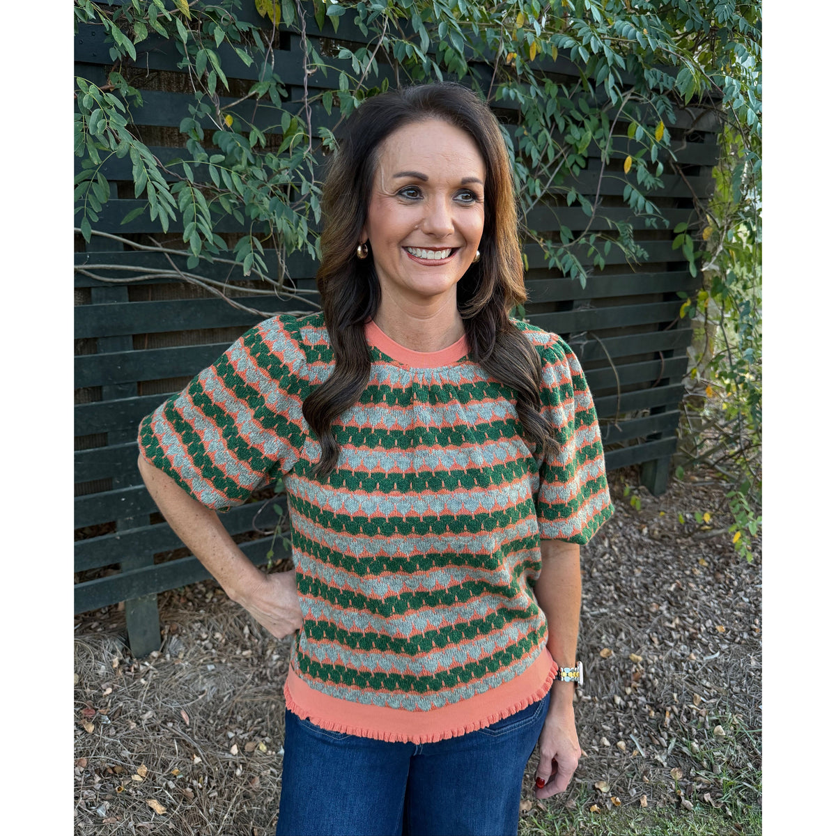 Annie Ks Boutique orange and green geometric stripe knit top with short bubble sleeves and ribbed trim on a woman