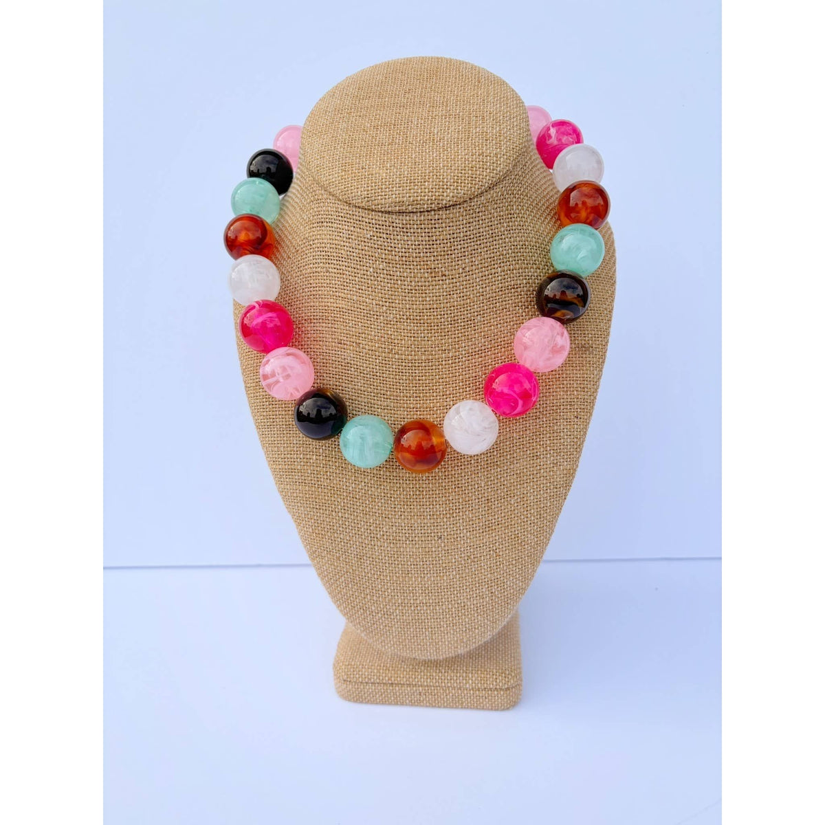 Annie Ks Boutique Pink Bauble Mix Necklace featuring glossy marbled beads in pink, black, and teal on a display bust.
