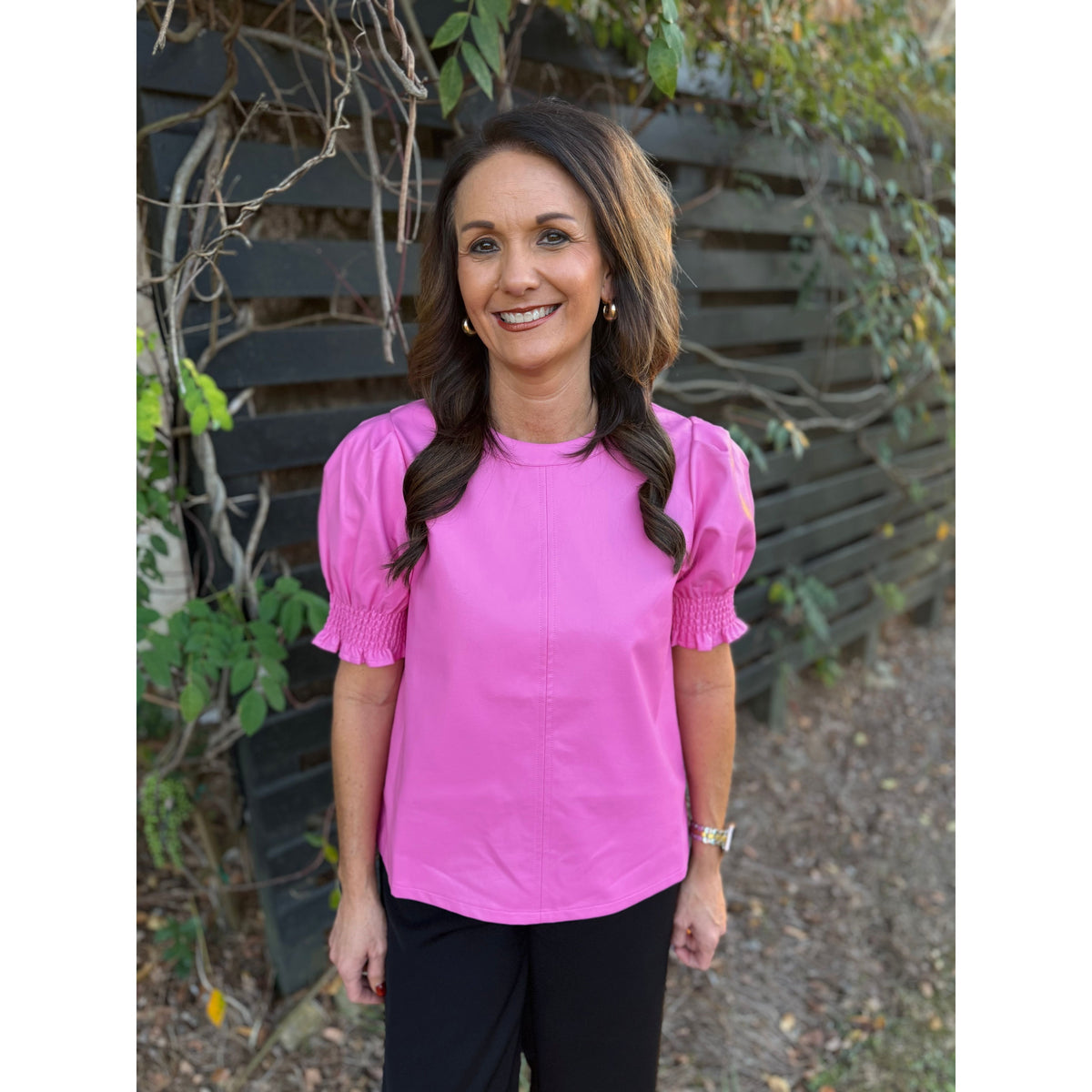 Annie Ks Boutique THML pink faux leather top with short puff sleeves and crew neck worn by a woman outdoors