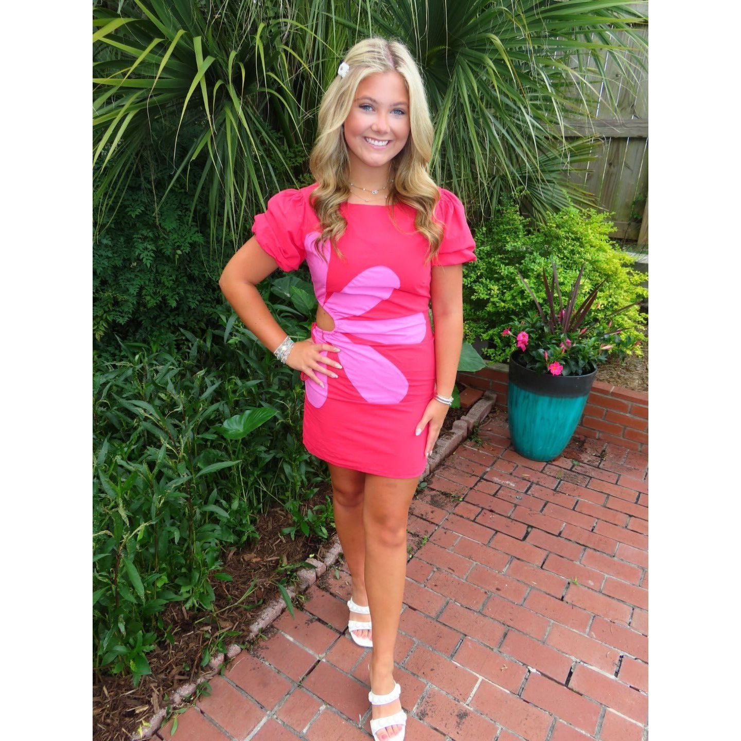 Annie Ks Boutique Primrose mini dress in pink cotton with a large flower appliqué, puff sleeves, and side cutout.