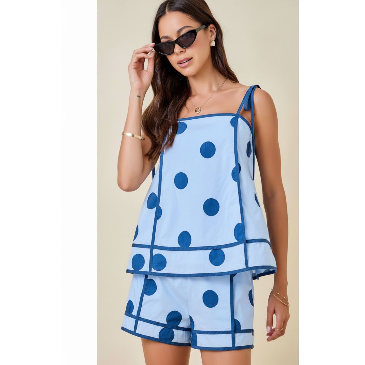 Model wearing Annie Ks Boutique light blue polka dot swing cami and high-waisted shorts set with contrast trim.