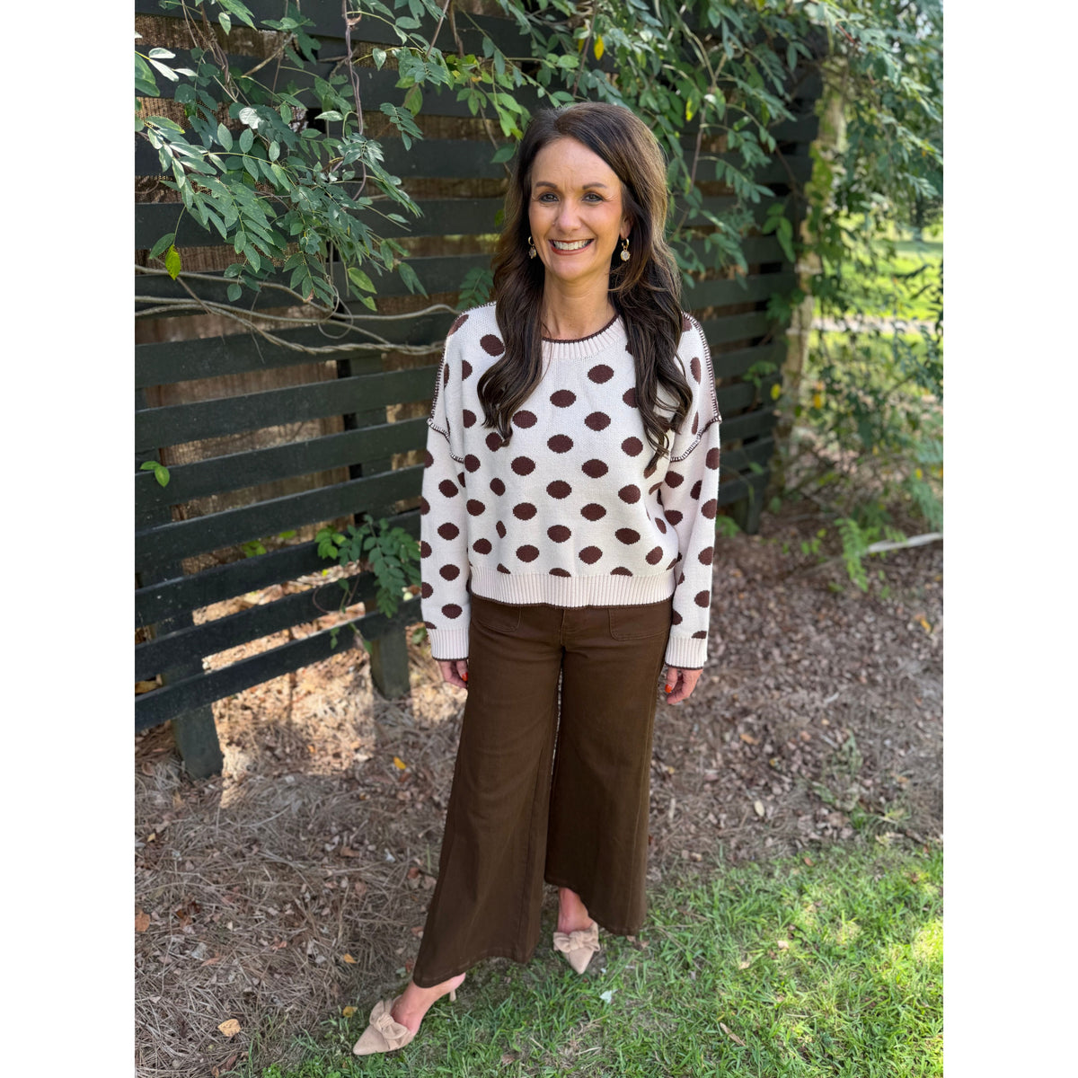 Annie Ks Boutique oatmeal and coffee polka dot loose fit sweater worn by a woman with brown trousers and heels