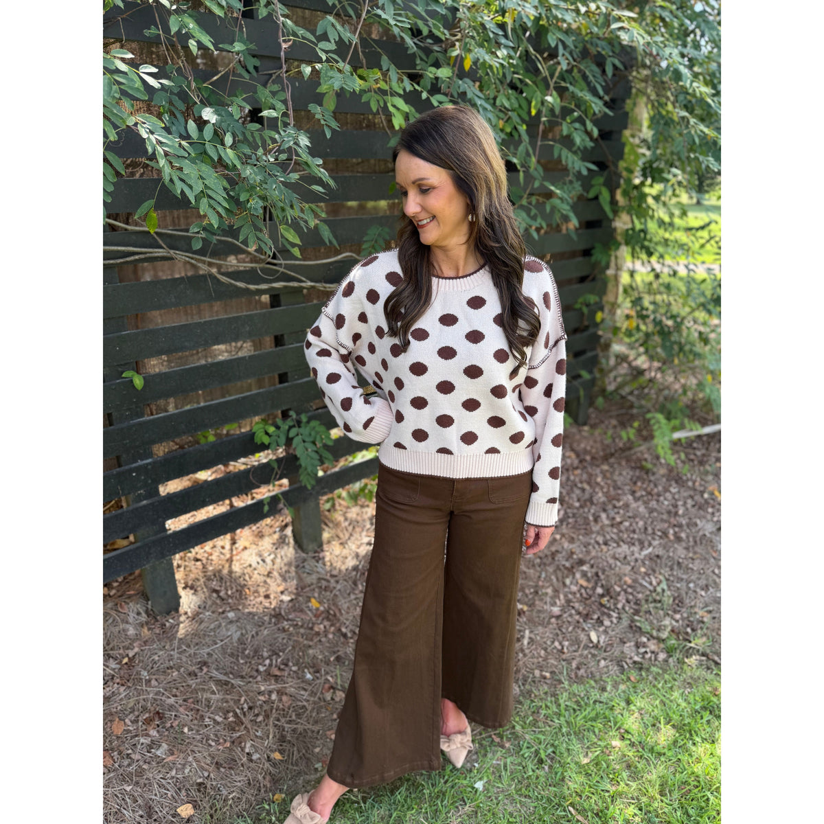 Annie Ks Boutique oatmeal and coffee polka dot loose fit knit sweater worn by a woman with brown trousers