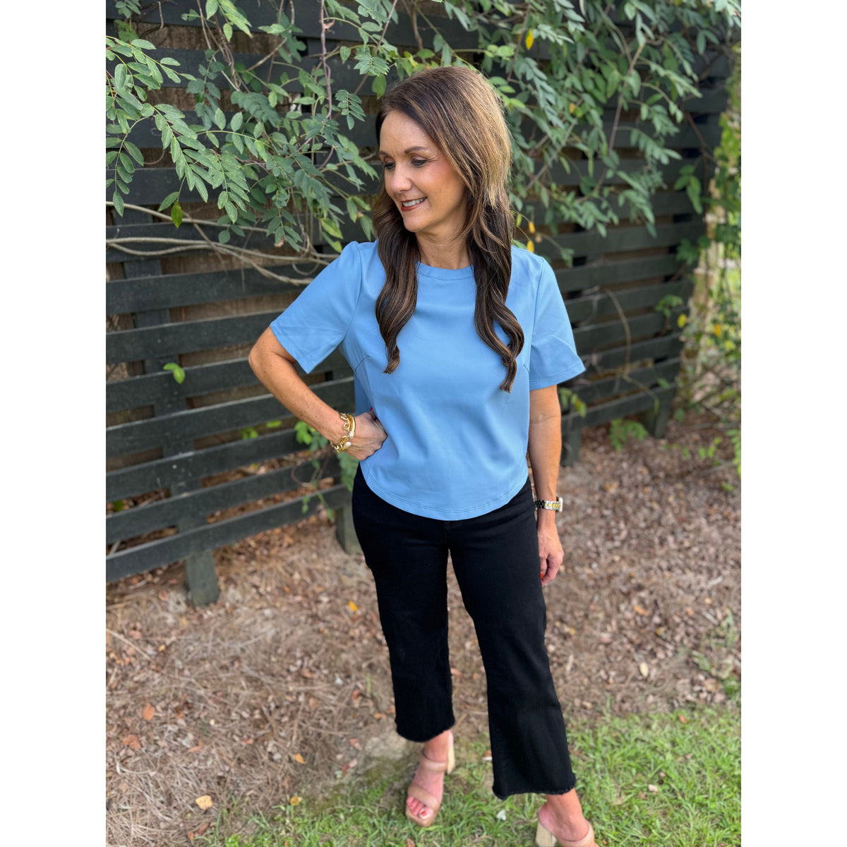 Annie Ks Boutique powder blue short-sleeve faux leather top worn by a woman with black cropped trousers