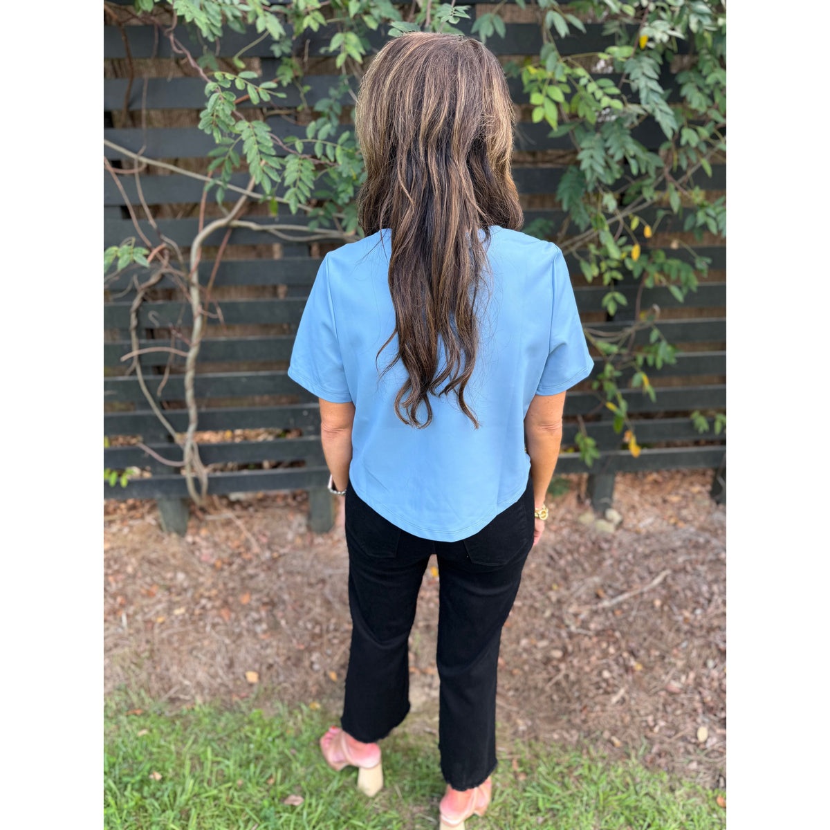 Annie Ks Boutique powder blue faux leather short-sleeve top worn by a woman with long hair, back view