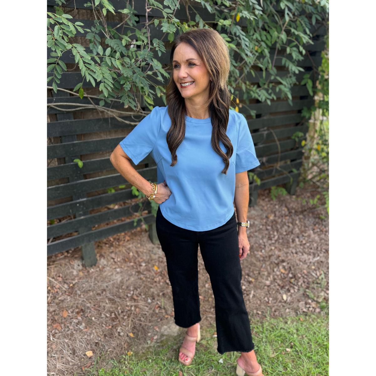Annie Ks Boutique powder blue faux leather short-sleeve top worn by a woman with black cropped trousers
