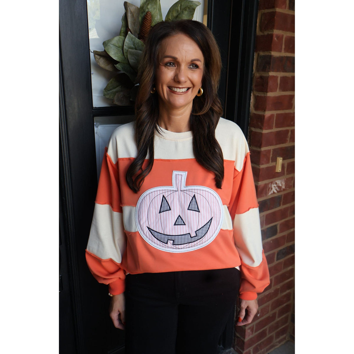 Annie Ks Boutique orange and cream color-block pullover with a large pumpkin appliqué for fall and Halloween wear
