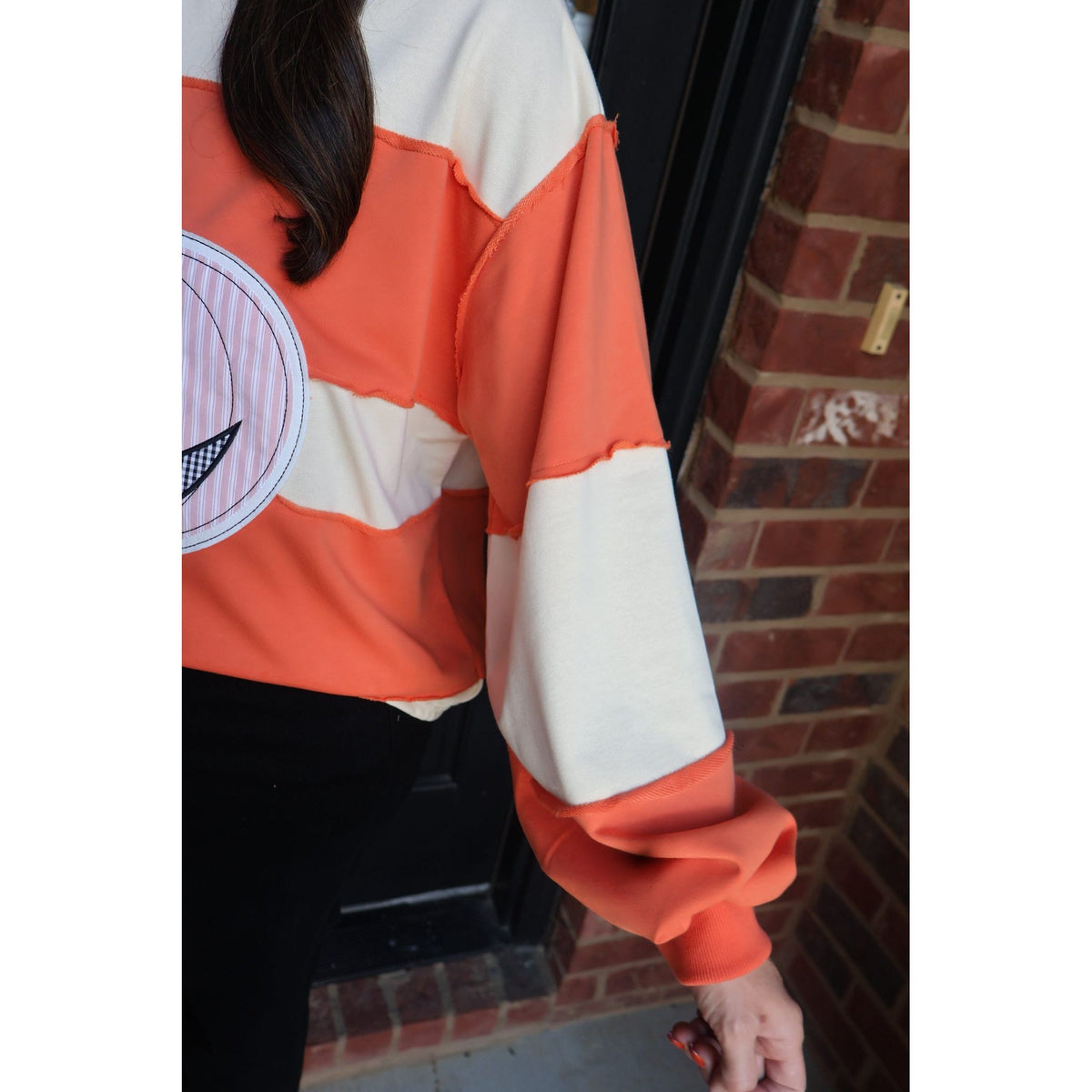 Annie Ks Boutique orange and cream color block pullover with pumpkin appliqué and exposed seam detail