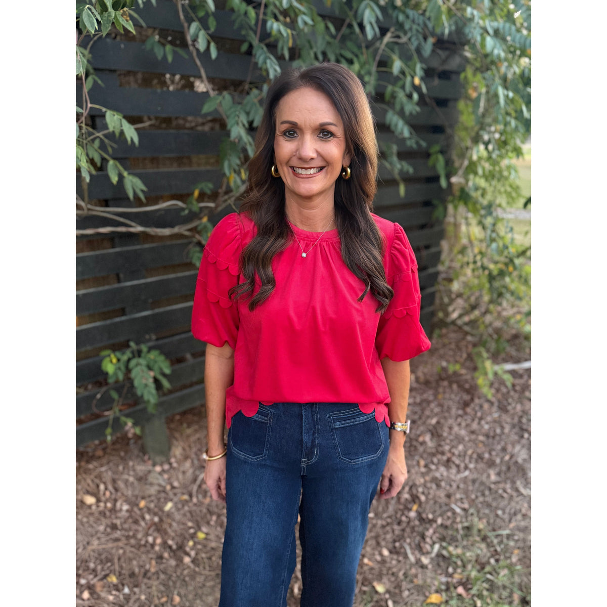 Annie Ks Boutique red corduroy top with bubble sleeves and scalloped hem worn by a smiling woman with dark hair.