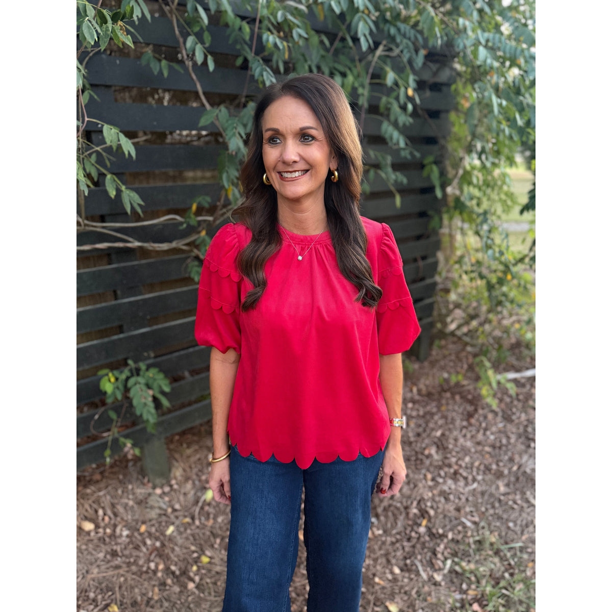 Annie Ks Boutique red corduroy top with bubble sleeves and scalloped hemline worn by a woman outdoors