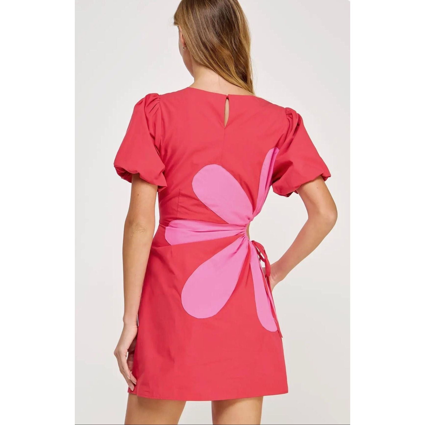 Annie Ks Boutique Primrose mini dress in red cotton with pink flower appliqué, puff sleeves, and side cutout detail.