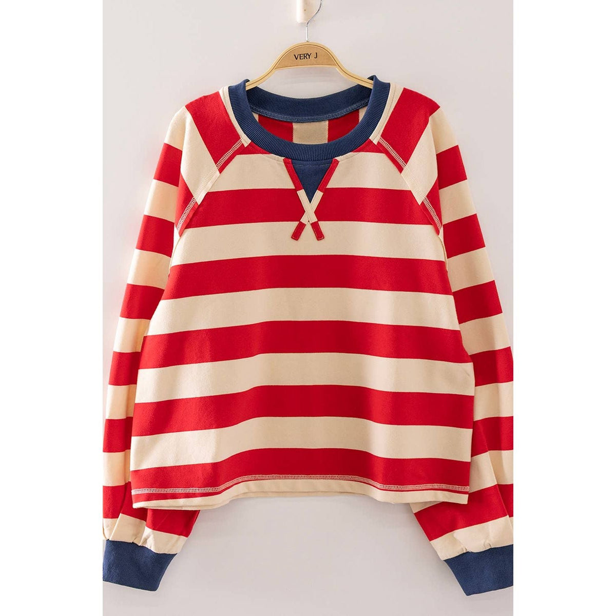 Annie Ks Boutique red and cream striped cropped top with a navy blue ribbed collar, raglan sleeves, and drawstring.