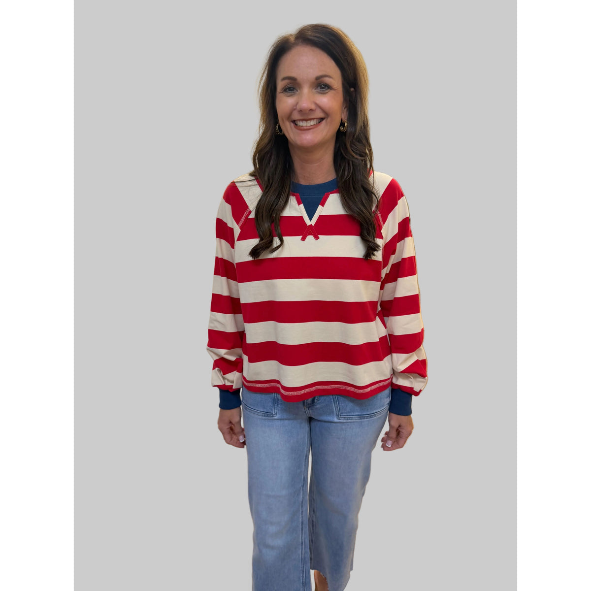 Annie Ks Boutique red and cream striped cropped top with raglan sleeves and drawstring neck worn by a smiling model