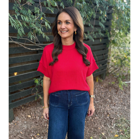 Annie Ks Boutique red crew neck sweater with half sleeves and drop shoulders worn with dark denim jeans outdoors