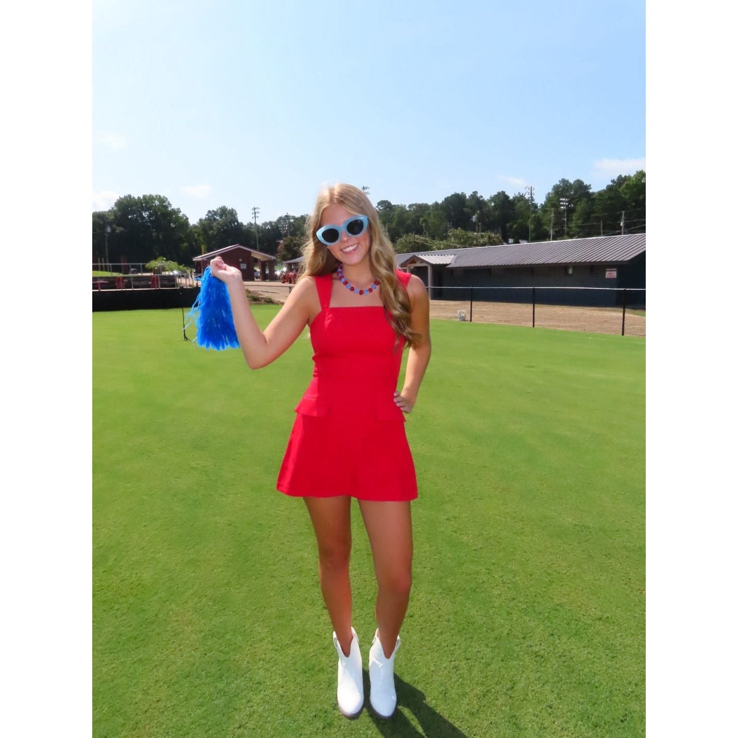 Annie Ks Boutique red mini skort romper with straight neckline and faux flap pockets worn by a woman with sunglasses