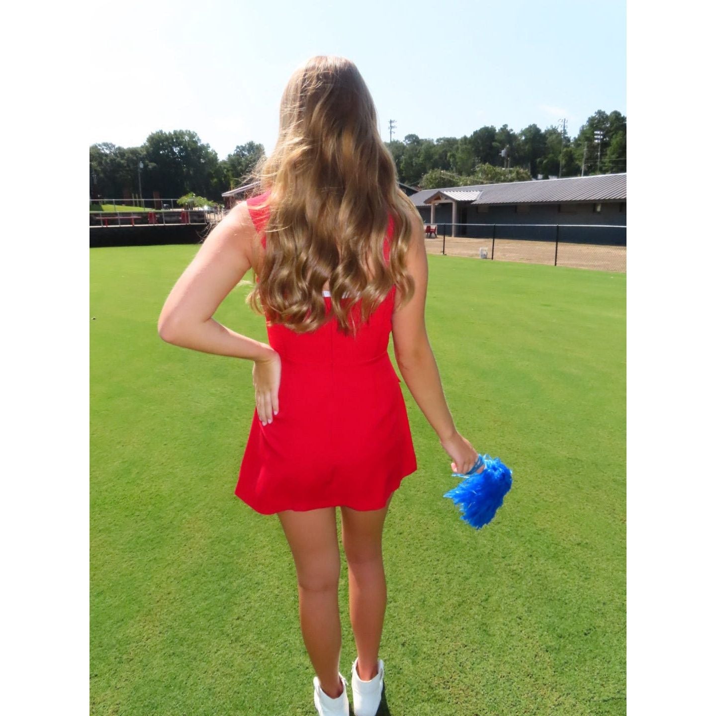 Annie Ks Boutique red mini skort romper worn by a woman on a grassy field, featuring a back zipper and flared fit.