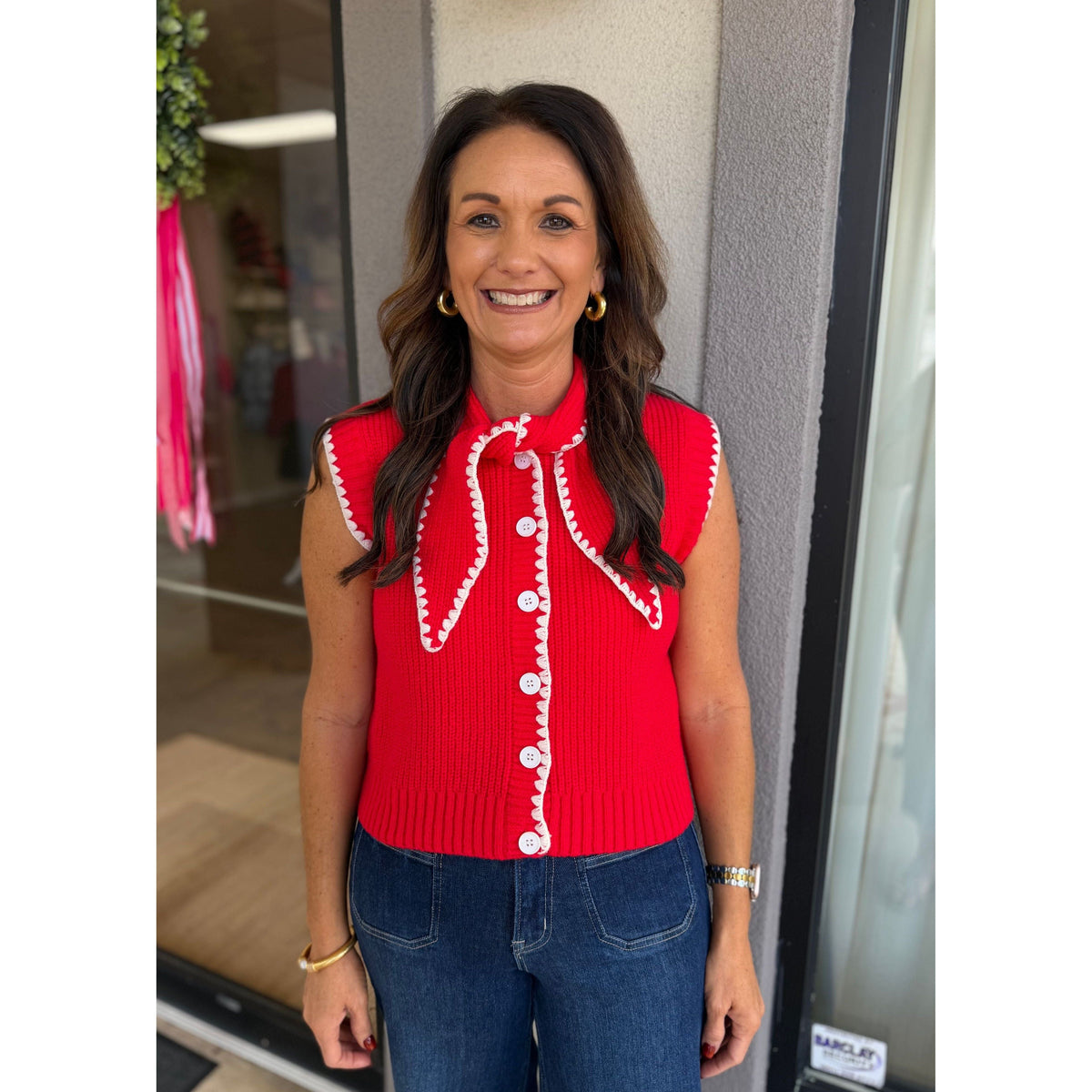 Annie Ks Boutique red and white sweater vest with tie neck, button front, and contrast blanket stitching.