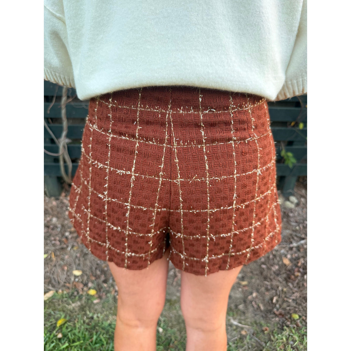 Back view of Annie Ks Boutique rust tweed skort featuring a metallic grid pattern, worn with a cream sweater.