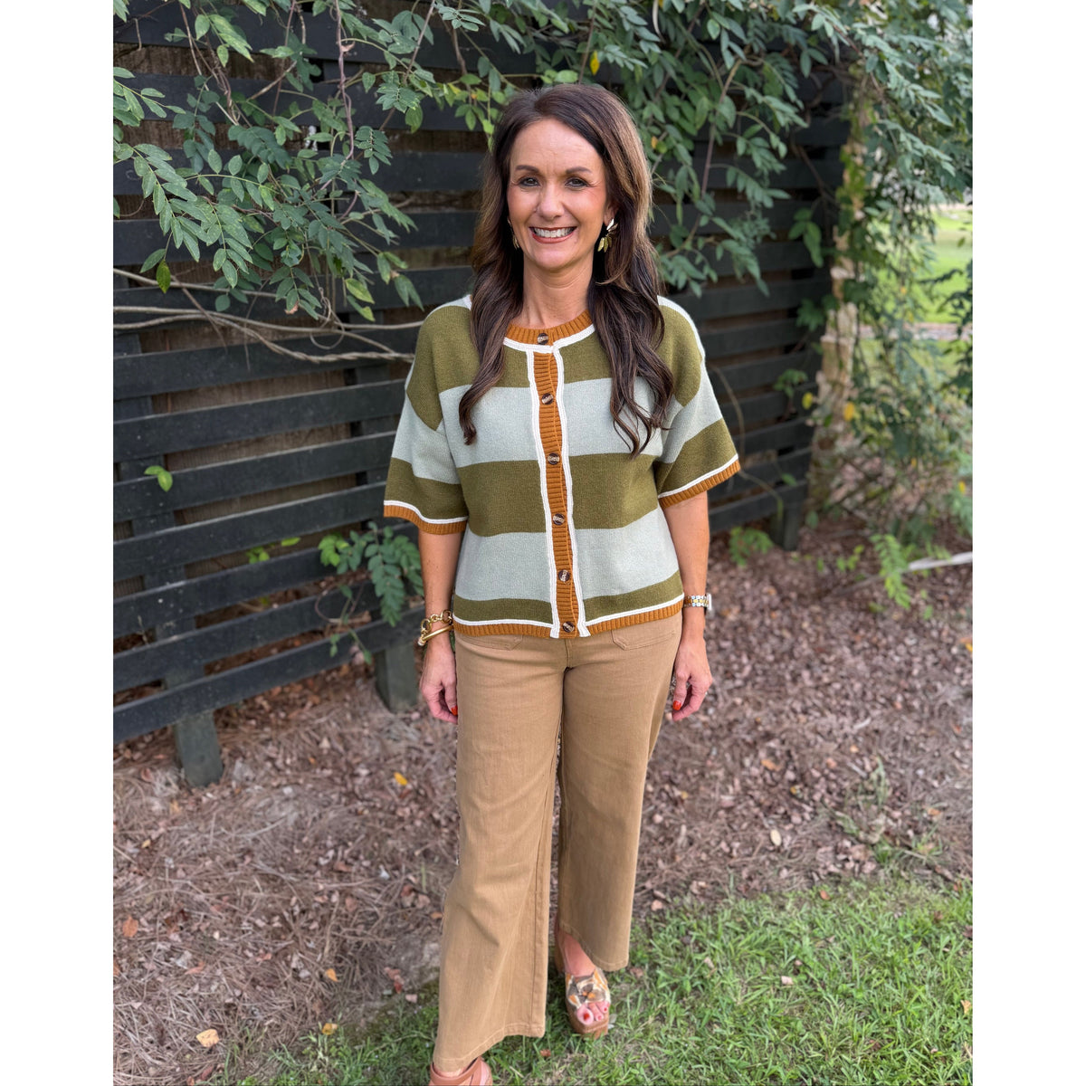 Annie Ks Boutique sage and olive wide striped cardigan with short sleeves and button front worn with tan trousers