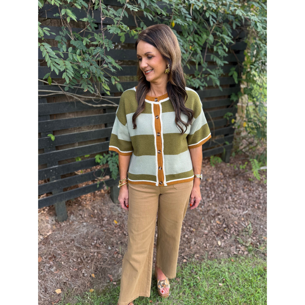 Annie Ks Boutique sage and olive wide striped cardigan with short sleeves and button front worn by a woman outdoors