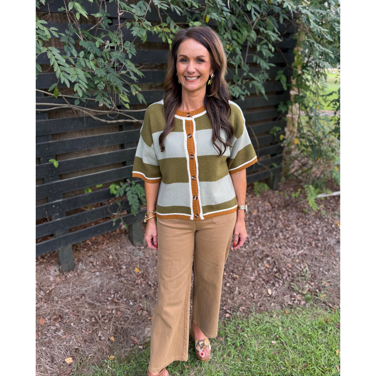 Annie Ks Boutique sage and olive wide striped short-sleeve cardigan worn by a woman with brown hair outdoors