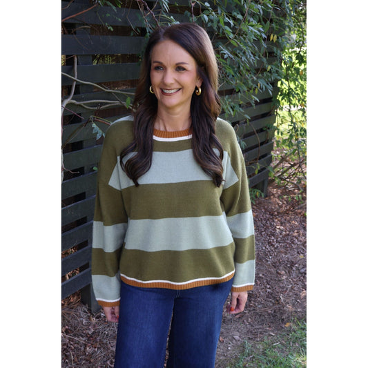 Annie Ks Boutique sage and olive green striped cozy knit sweater with a crew neck worn by a woman outdoors.