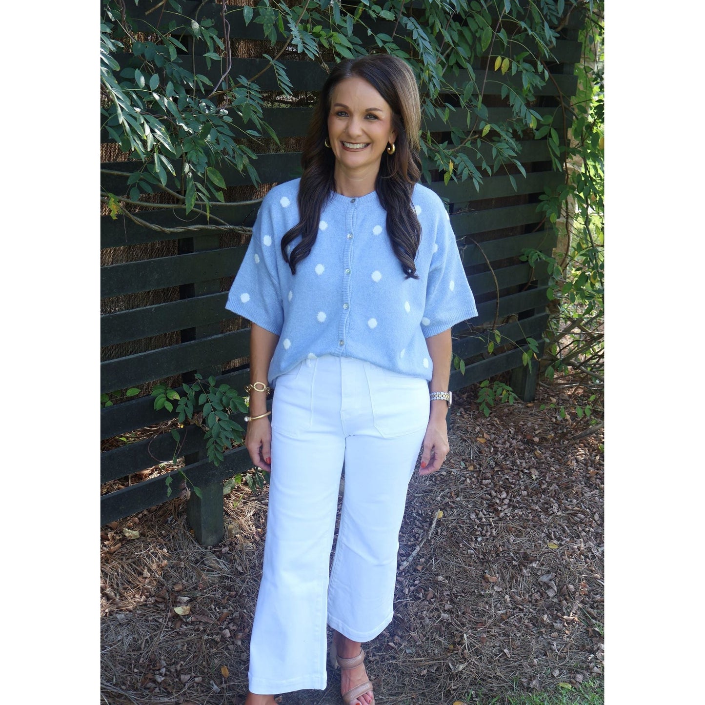 Annie Ks Boutique sky blue knit cardigan with white polka dots, crew neck, and short sleeves worn with white pants.