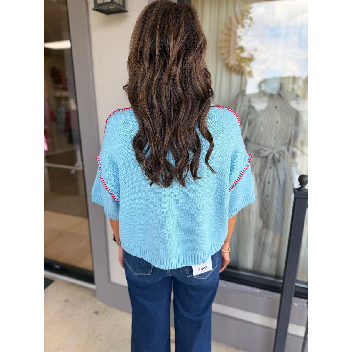 Annie Ks Boutique sky blue short sleeve sweater with red blanket stitch detail worn with dark wash jeans