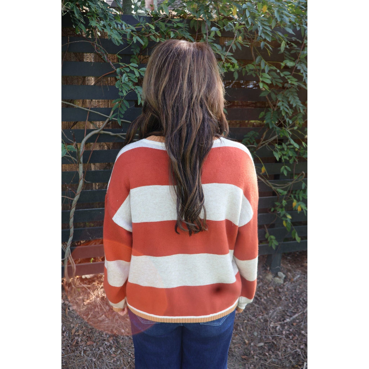 Annie Ks Boutique oatmeal and brick red striped knit sweater worn from the back with a relaxed fit and crew neck.