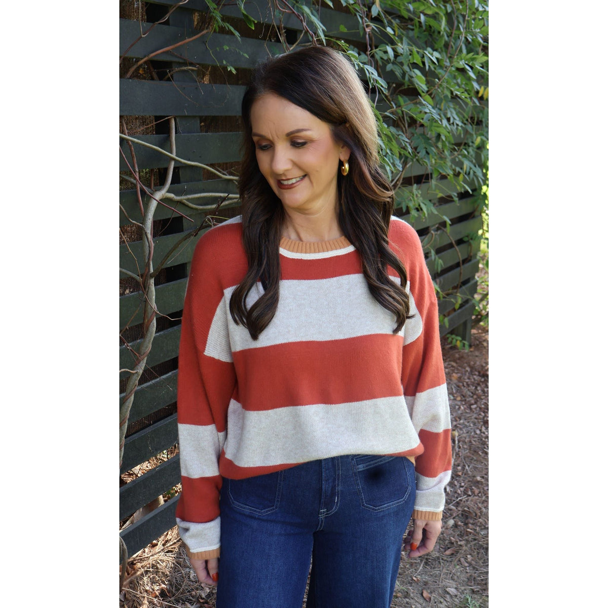 Annie Ks Boutique oatmeal and brick red striped knit sweater with a crew neck worn by a woman with dark hair