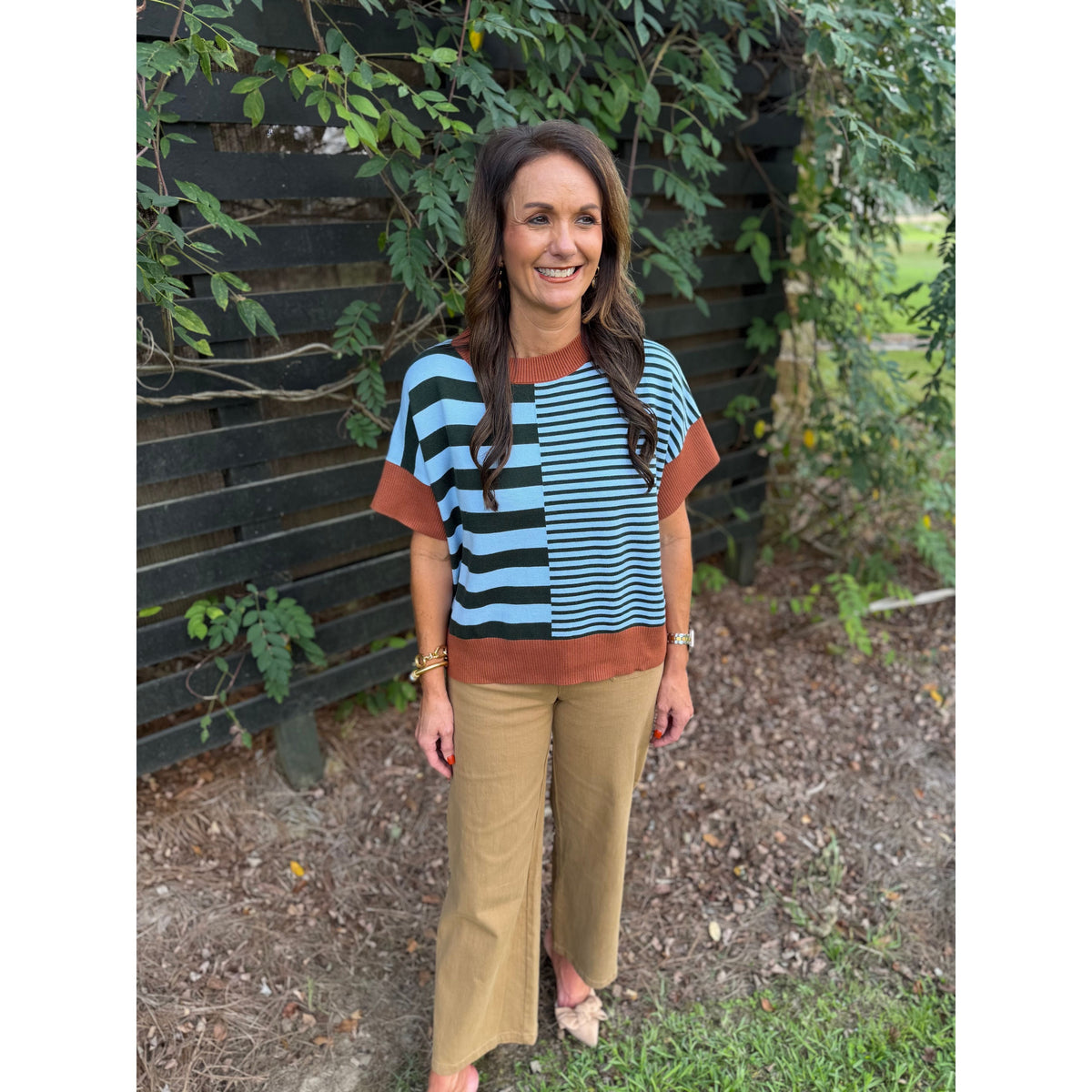 Annie Ks Boutique caramel and sea green striped drop-shoulder sweater worn by a woman with brown hair outdoors.