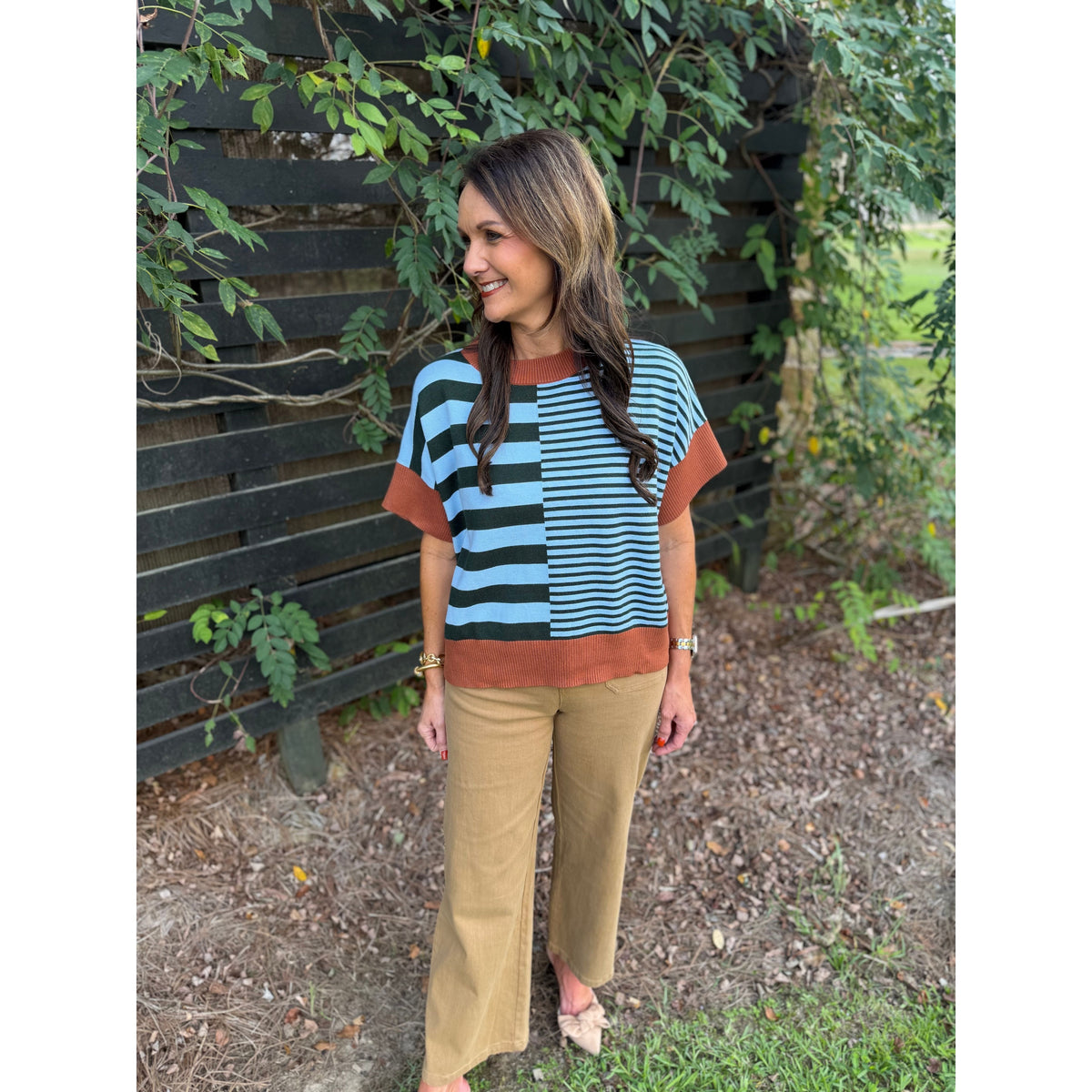 Annie Ks Boutique caramel and sea green striped drop-shoulder sweater worn by a woman with brown trousers